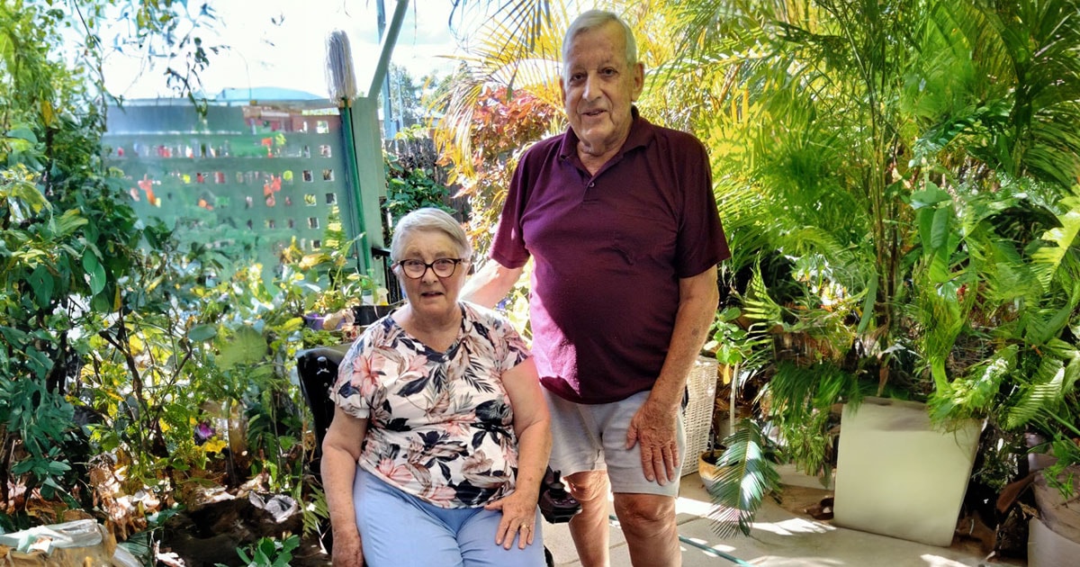 BlueCare Rockhampton residents Rob and Barbara Badman in garden smiling at camera