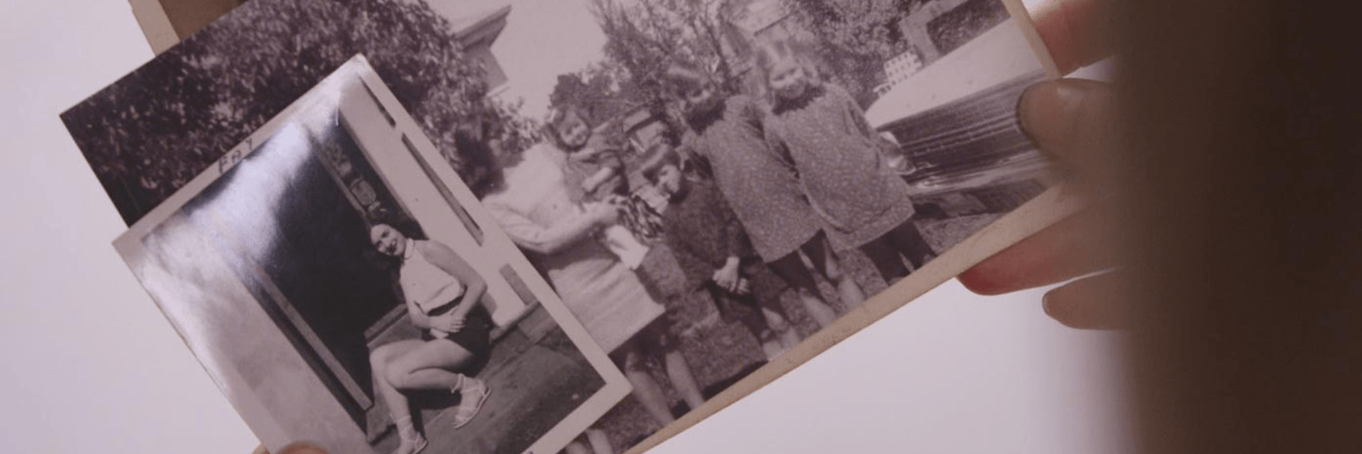 Memories of a life well lived Hands hold a series of old photographs of a young woman in a doorway and a young mum with four children.