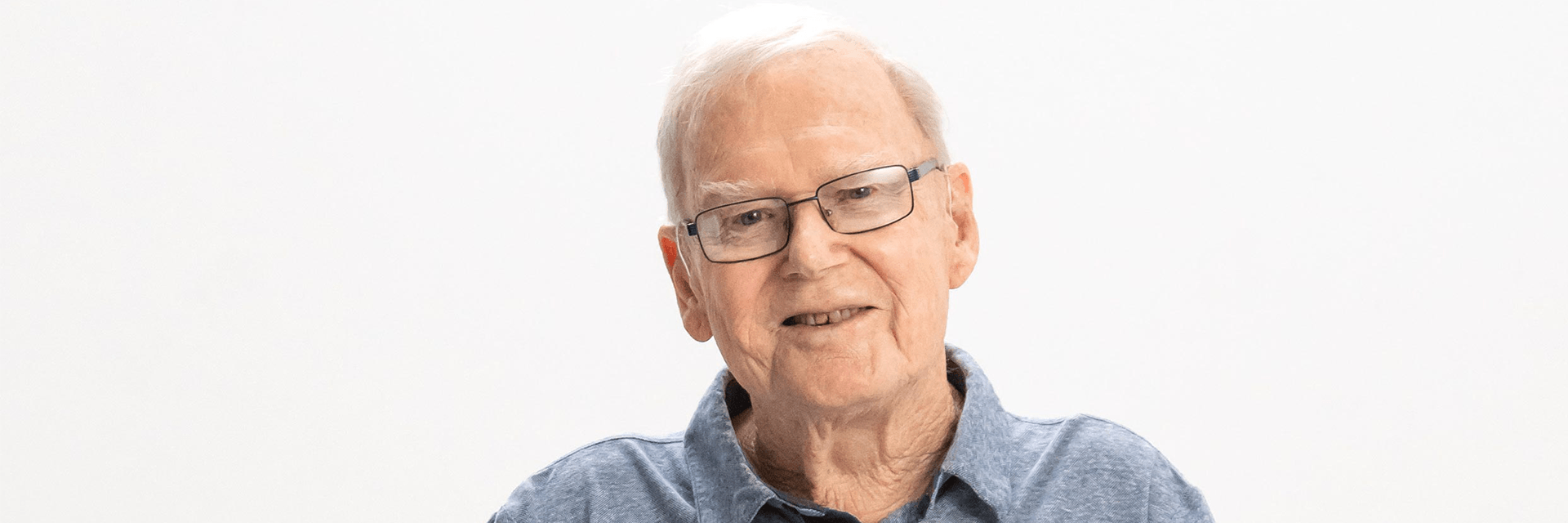 Blue Care client bob smiling at camera on a white background