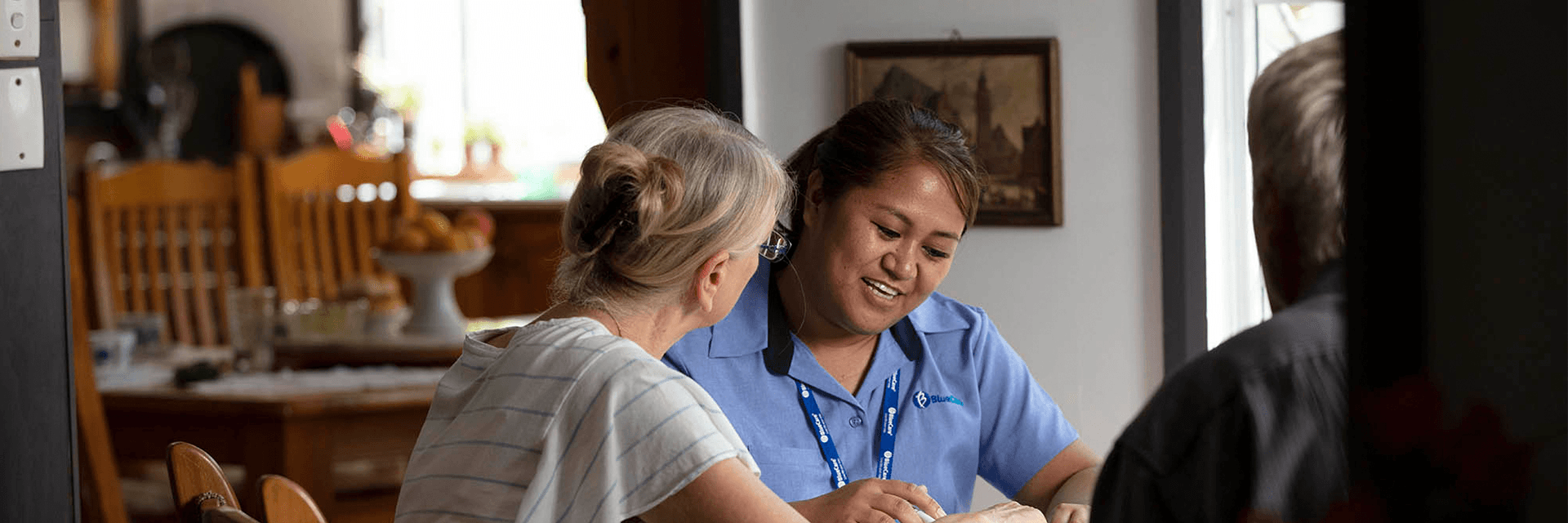 A Blue Care employee reviews documents with an older couple