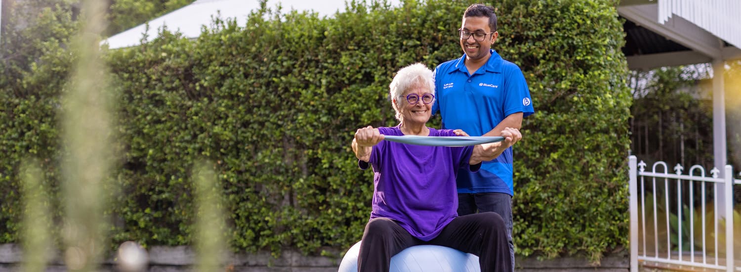 A BlueCare employee helps an older lady