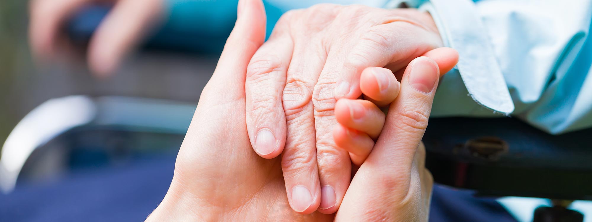 A close up of and older and young person holding hands
