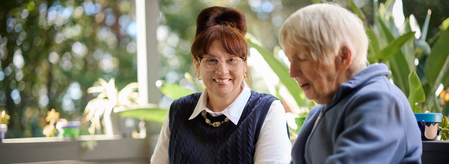 A BlueCare employee smiles at an older woman