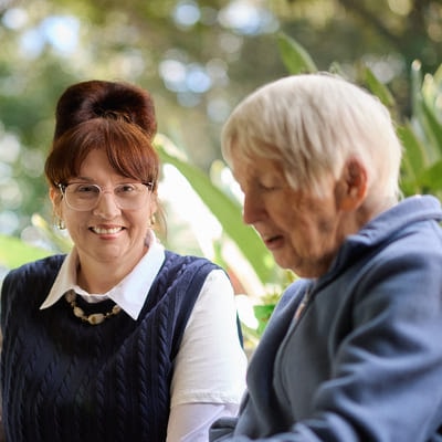 A BlueCare employee smiles at an older woman