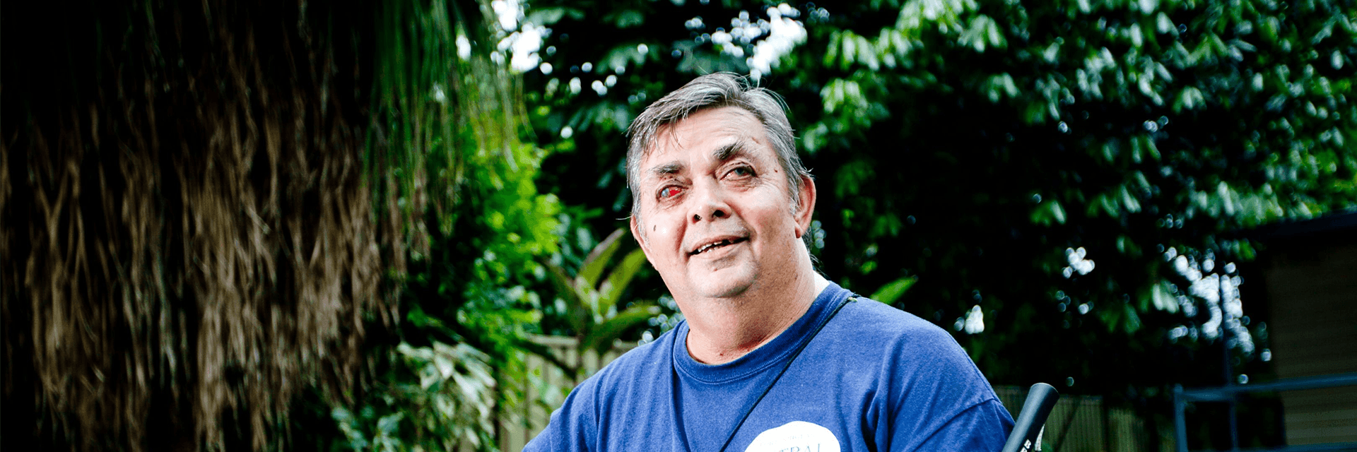 A picture of Ted smiling at the camera in his backyard