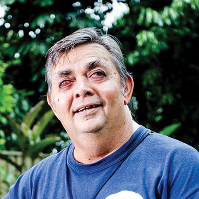 A picture of Ted smiling at the camera in his backyard