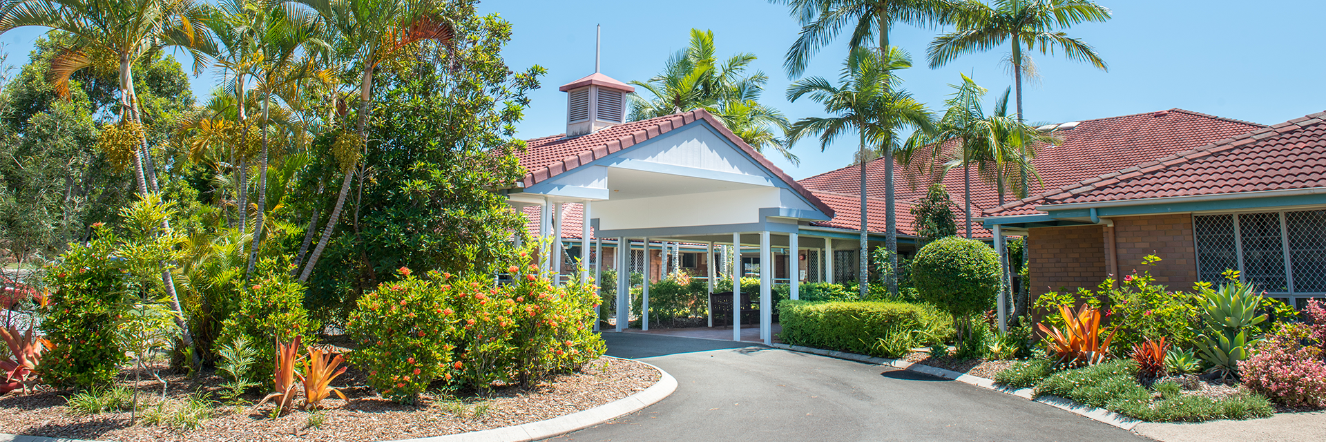 Blue Care Bli Bli Aged Care Facility Palm trees and tropical gardens create a welcoming entrance to Blue Care Bli Bli Aged Care Facility.