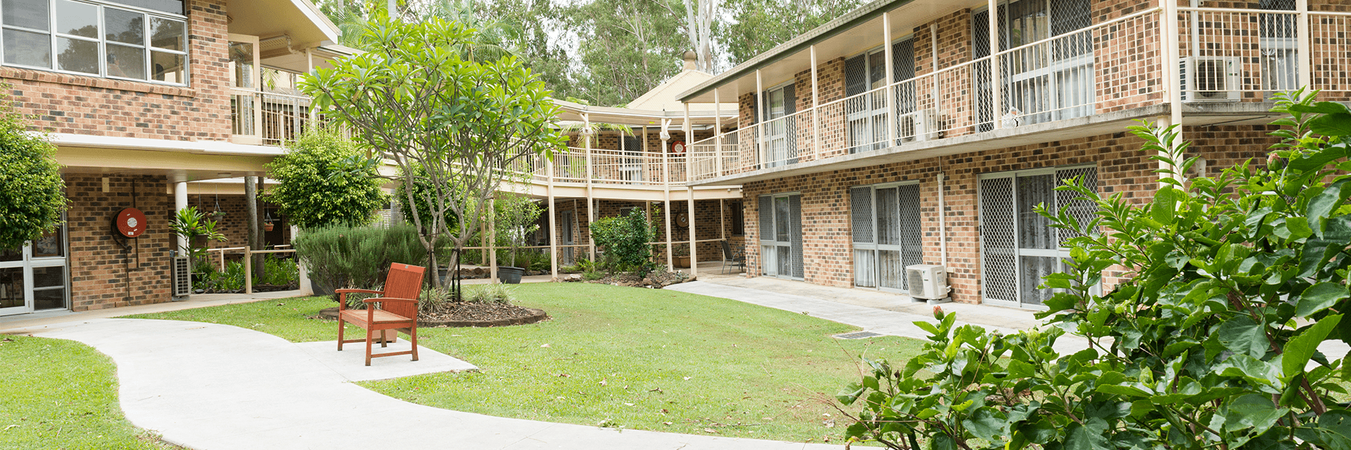 A pretty garden view at Blue Care Kenmore Aged Care Facility The double-story brick buildings at Blue Care Kenmore Aged Care Facility feature balconies that overlook the gardens.