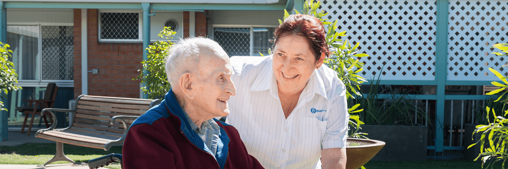 Sunshiny days at Blue Care Mackay Homefield Aged Care Facility An older gentleman in a wheelchair catches some sun in the company of a woman who works at Blue Care Mackay Homefield Aged Care Facility.
