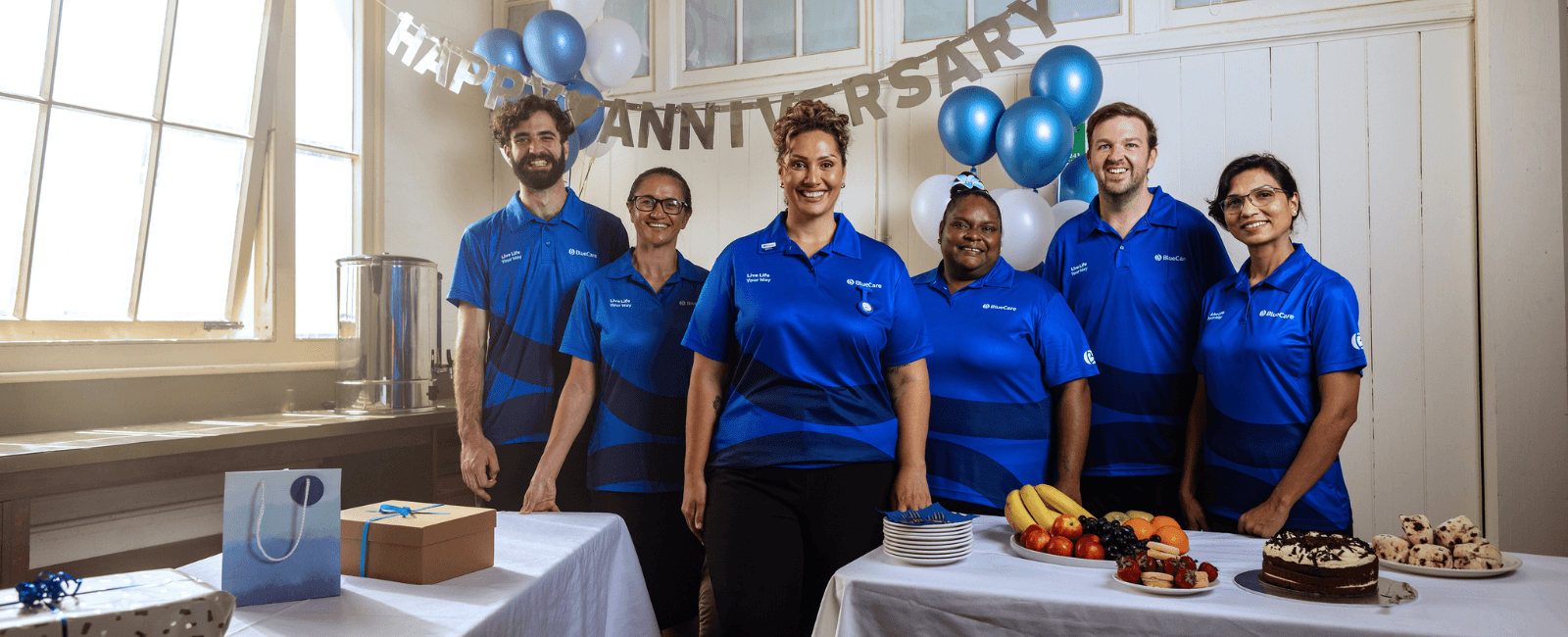 Team of BlueCare team standing around table